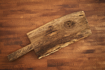 Old wooden cutting board on wooden background