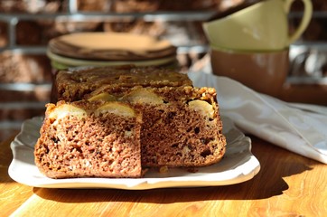 Apple and peach cake outdoors on a wooden table in sunshine. selective focus