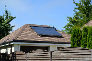 Fototapeta na wymiar Solar water-heating installation on a garage roof