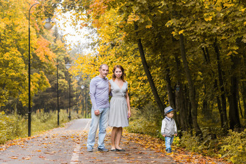 Naklejka na ściany i meble friendly family walking in the park in autumn together