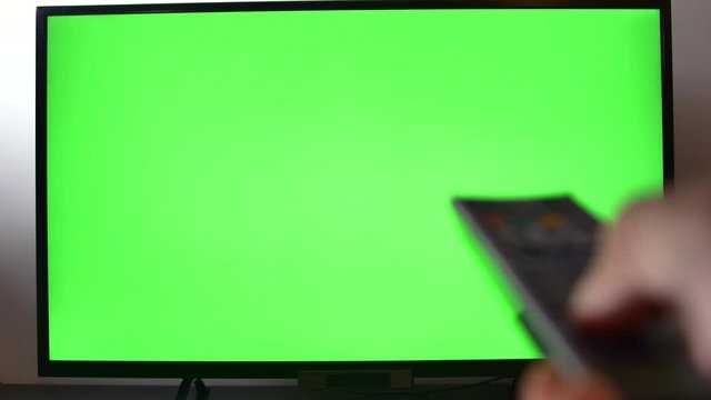 Right Handed Man Adjusting Sound Volume On His TV Set, Hand Detail, Green Screen