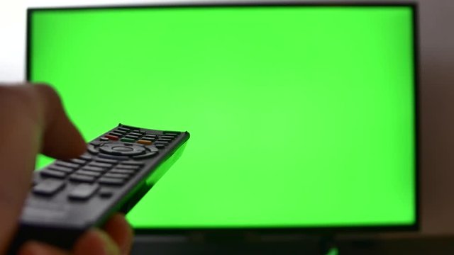 Left Handed Man Changing Channels Of His TV Set, Green Screen