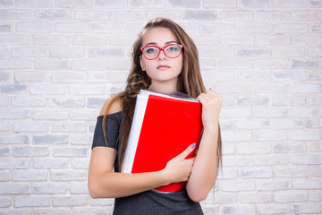 Long-haired girl imitates business lady with red folder