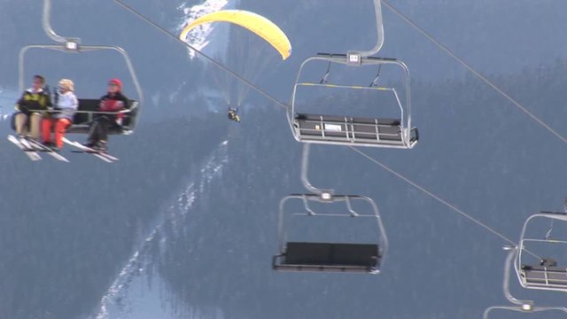 Ski elevator with a paragliding on the background
