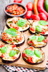Baked  eggplant with cheese and tomatoes on cutting board