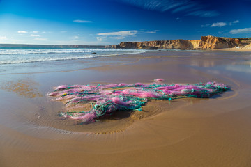 Plastic waste and residues of large fishing nets stranded on Tonel beach, Sagres, Portugal - 121282352