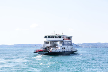 Ferry boat transporting cars on a lake Lago di Garda
