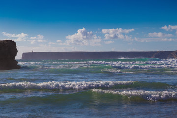 Huge ocean waves and Saint Vincent Cap seen in background, South Portugal