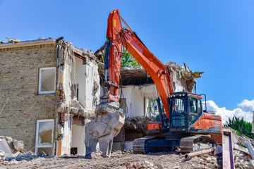 Baugewerbe - Abbrissbager vor einer Hausruine