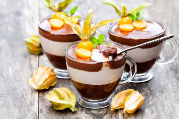 Layered  dessert with physalis on wooden table