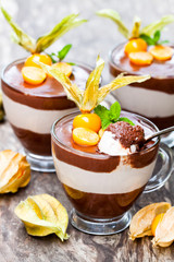 Layered  dessert with physalis on wooden table
