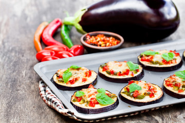 Fototapeta na wymiar Baked eggplant with cheese and tomatoes on baking tray