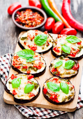 Baked  eggplant with cheese and tomatoes on cutting board