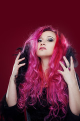 Attractive woman with pink hair in witch image. Halloween style