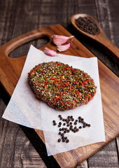 Beef raw steak with pepper and garlic on wood