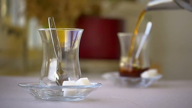 Slow Motion serving Turkish tea with sugar cubes and a teaspoon. Turkish Tea served from traditional 2 tiered teapot. (Bottom one for boiling water and top pot for brewed tea). High Quality Camera Ori