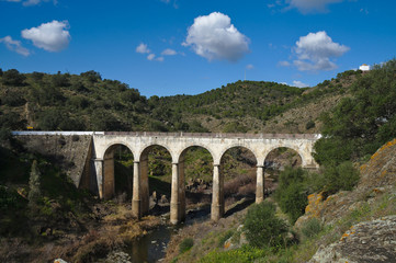 Fototapeta na wymiar Antique Mertola's bridge over Oeiras Creek (Ribeira de Oeiras). Alentejo, Portugal.