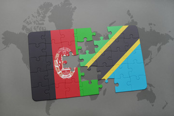puzzle with the national flag of afghanistan and tanzania on a world map background.