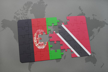 puzzle with the national flag of afghanistan and trinidad and tobago on a world map background.