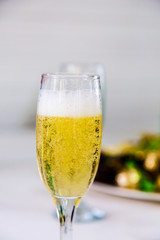 One glass of champagne is a white table against the window on the veranda outside the city. Wedding.