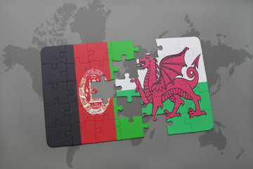 puzzle with the national flag of afghanistan and wales on a world map background.