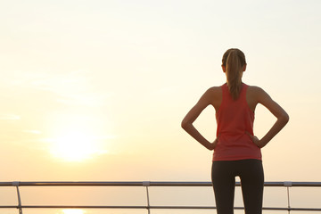 Young woman doing exercises on pier