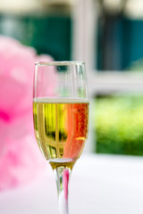 One glass of champagne is a white table against the window on the veranda outside the city. Wedding.