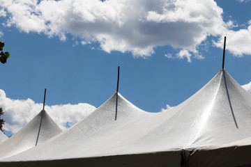 Three peaks of a white party tent and sky