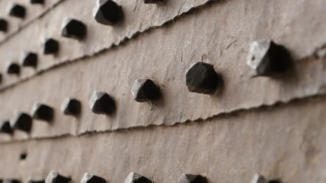 Shallow DOF ancient castle entrance gate of steel detailed surface 4K 2160p UHD slow tilt video - Tilting on metal pins or nails in old door 3840X2160 UltraHD footage 