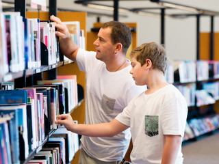 Boy and his father in library