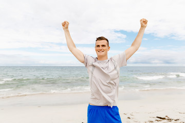 Young man in sport wear with outstretched arms