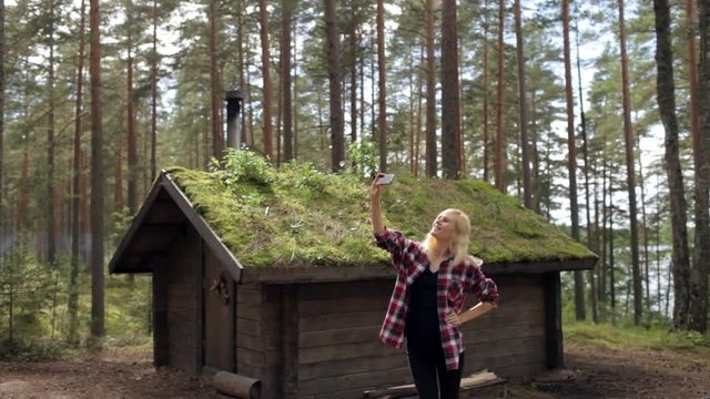 Woman it Makes Selfie Next to a Wooden House in the Woods