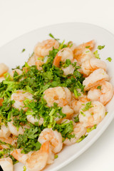Fried shrimps with the greens. Easy seafood snack on white background close-up.