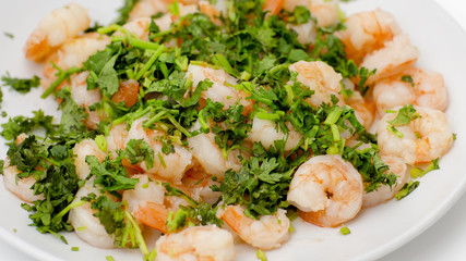 Fried shrimps with the greens. Easy seafood snack on white background close-up.