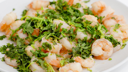 Fried shrimps with the greens. Easy seafood snack on white background close-up.