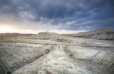 Woman with backpack in the desert mountains