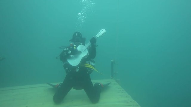 Scuba Diver plays guitar underwater
