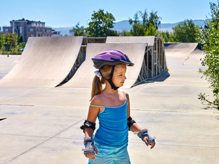 Sport girl riding on roller skates in skatepark. Summer sport park.