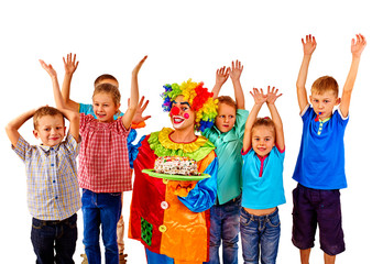 Fototapeta premium Clown keeps birthday cake with group children hands up. Isolated.