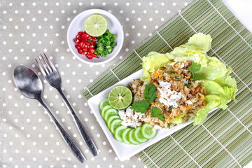 Fried rice with crab topped streamed crab,halve green lemon,sliced cucumber,lettuce and coriander  served  spicy  sour filling side dish.  Top view 