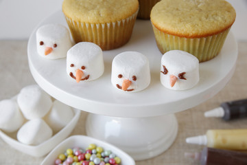 Preparing fun homemade melting snowman cupcakes for kids