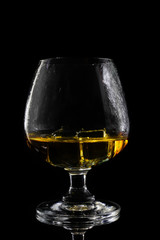 Whiskey in glass and ice on a black background.