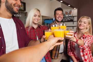 People Friends Drinking Orange Juice, Toasting At Bar Counter, Mix Race Man And Woman Cheers
