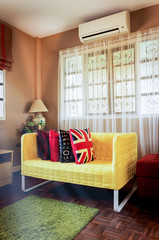 yellow fabric sofa in brown living room & morning sunlight shining from windows for asian modern...