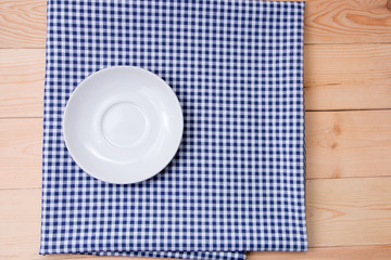 empty plate over fabic on wood background