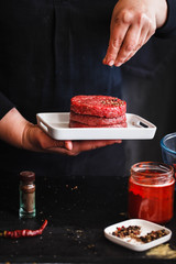 Raw Burger homemade prepared with seasoning for dinner party.