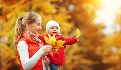 happy family mother and baby laugh  in nature autumn