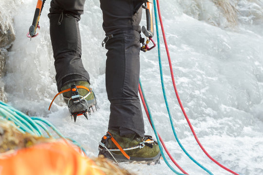 Close up of Ice climbing mountaineer legs with professional sport boots and equipment