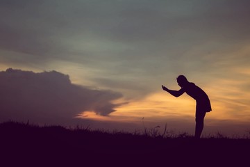 silhouette of woman Standing blessings of god at sunset