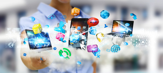Businessman holding tech devices and icons applications over a c © sdecoret
